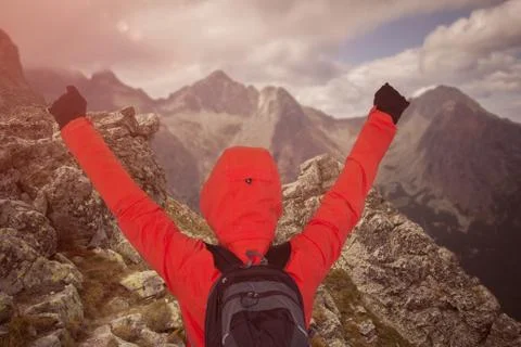 Man at mountain summit with hands up Stock Photos