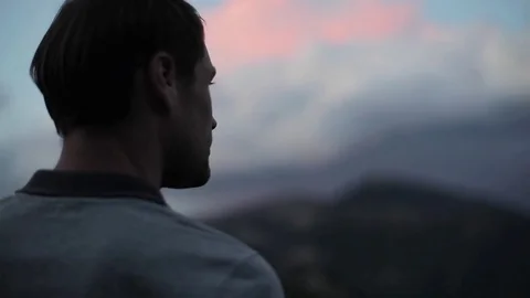 Man on mountain top looks down determined to conquer world close up slow motion Stock Footage 79965872