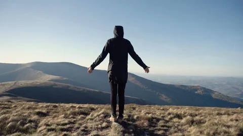 Man on mountain top looks down determined to conquer the world . Male head silho Stock Footage 98377586