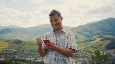 A man in the mountains use phone technology smile sunny day a concept of Stock Footage 116997652