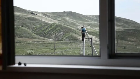 Man mounts electricity outside the window Stock Footage 79341212