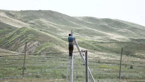 Man mounts electricity on a pole Stock Footage 79407646