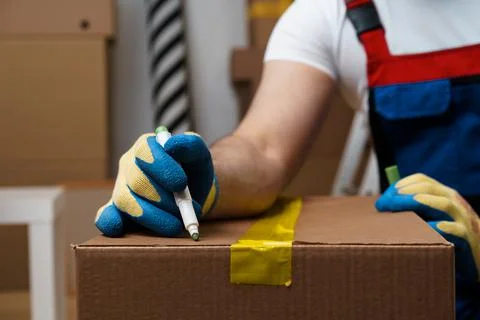 Man mover in uniform packing boxes for relocation Stock Photos