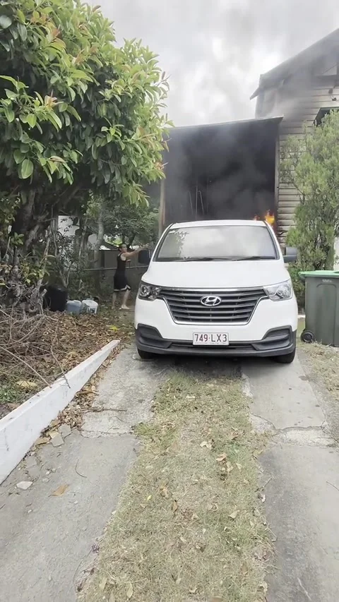 Man Moves Burning Car Away From Brisbane Home, Brisbane, Australia - 08 Feb 2026 Stock Footage 329071129