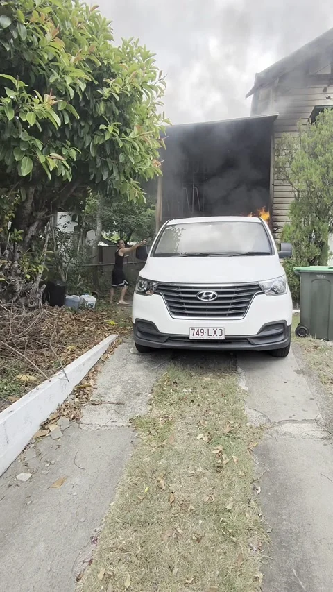 Man Moves Burning Car Away From Brisbane Home, Brisbane, Australia - 08 Feb 2026 Stock Footage 329071130