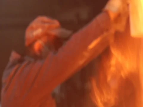 Man Moves Lid/ Fire In Foreground Stock Footage 1089626