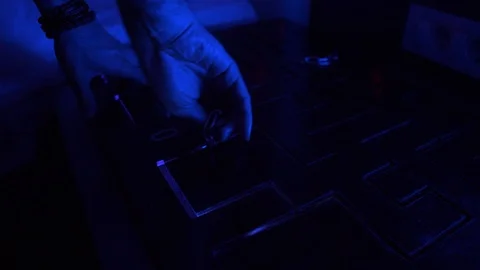 A man moves a small key on a chain along lines of the maze on the table. Puzzle Stock Footage 111699947