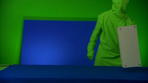 Man moving a box in front of blue/green screen, advert concept Stock Footage 89581783