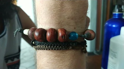 Man moving handmade bracelets at his hand Stock Footage 111503060