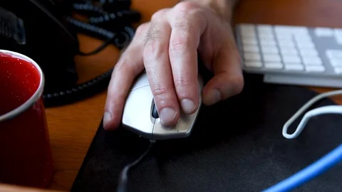 A man moving his computer mouse on a mouse pad on his desk. Video stock 128595715