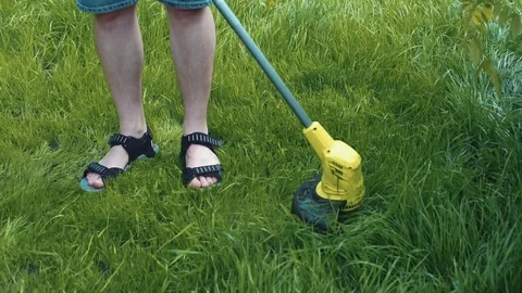 Man moving the lawn with electrical grass cutter Stock Footage 107793001