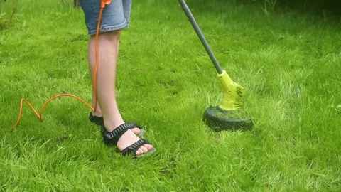 Man moving the lawn with electrical grass cutter Stock Footage 107793012