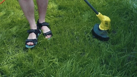 Man moving the lawn with electrical grass cutter Stock Footage 107793026