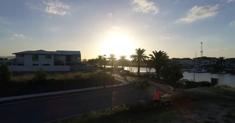 Man mowing ascending to view sunset by drone Stock Footage 75956683