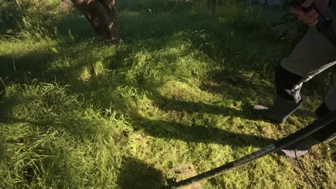 Man mowing grass with electric trimmer angled top view with power cable Stock Footage 340142955