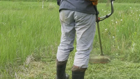 A man mowing the grass in the garden close-up Video stock 76468134
