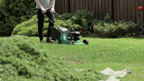 Man mowing lawn in the backyard of his Stock Video Pond5