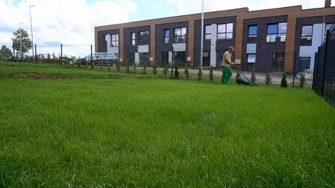 Man is mowing lawn on cloudy day. Wide angle timelapse Stock Footage 115039622