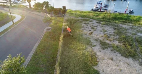 Man mowing long grass by drone Stock Footage 75956807