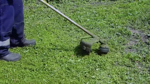 A man mows the grass with a lawn mower. Stock Footage 197785393