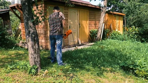 Man mows the grass with a trimmer Stock Footage 78307945