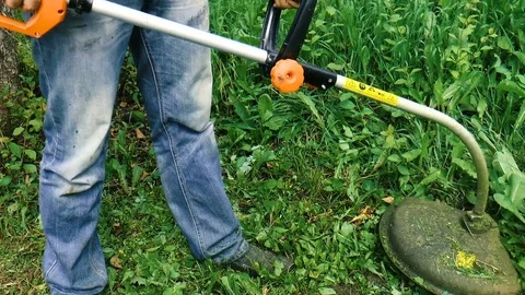 Man mows the grass with a trimmer Stock Footage 78421090