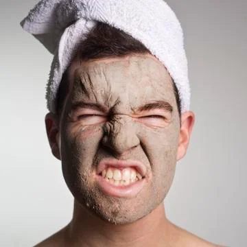 Man with a mud mask on this face Stock Photos