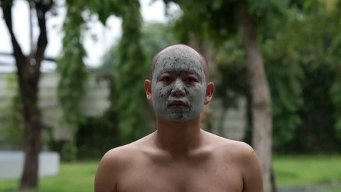 Man with mud mask on his face outdoor. Stockbeeldmateriaal 124822131
