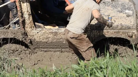 Man in the mud trying to help Stock Footage 71504503