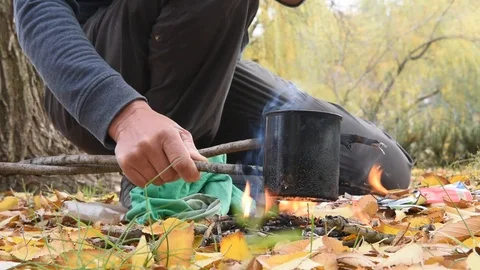 A man mug of tea at the stake. Autumn flame Stock Footage 101355933