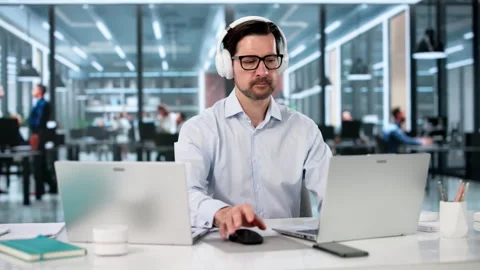 Man Multitasking On Two Laptops In Office Stock Footage 335458047