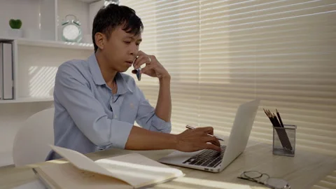 Man Multitasking, Typing on Laptop and Talking on Phone at Home Office , Home Stock Footage 263479254