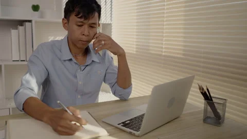 Man Multitasking, Typing on Laptop and Talking on Phone at Home Office , Home Stockbeeldmateriaal 263479343