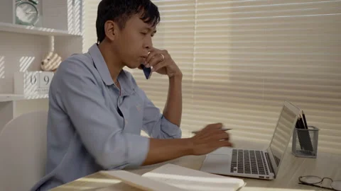 Man Multitasking, Typing on Laptop and Talking on Phone at Home Office , Home Stockbeeldmateriaal 263479466