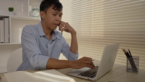 Man Multitasking, Typing on Laptop and Talking on Phone at Home Office , Home Stockbeeldmateriaal 263479662