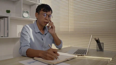 Man Multitasking, Typing on Laptop and Talking on Phone at Home Office , Home Stockbeeldmateriaal 263480048