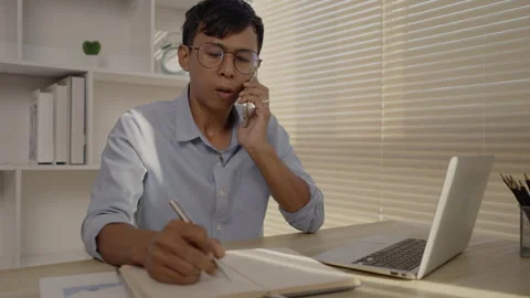 Man Multitasking, Typing on Laptop and Talking on Phone at Home Office , Home Stockbeeldmateriaal 263480315