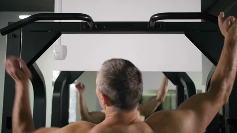 A man with a muscular back pulls up on a simulator 4K Slow Mo Stock-Footage 100258701