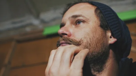 A man with a mustache and beard with beautiful blue eyes combing his beard Stock Footage 103300096