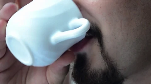 Man with mustache and beard who smiles after drinking a cup of white porcelai Stock Footage 80262919