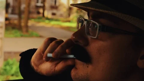 Man with mustache in hat, glasses sitting in car with cigarette. Summer. Parody Vidéo 75313832
