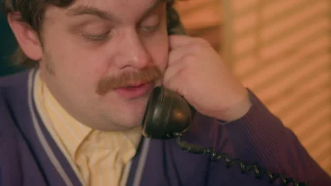 Man with a mustache have conversation on wired phone in his retro-style office Stock Footage 263309008