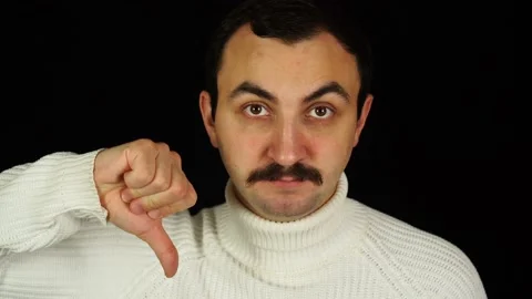 Man with mustache holding thumb down over black background Stock Footage 144484094