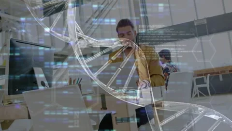 Man in mustard jacket typing at laptop activating DNA helix, code overlays for Stock Footage 334114150