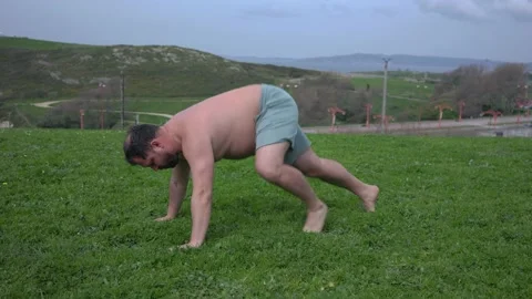 A man with a naked torso, doing exercises on the grass Video stock 189921275