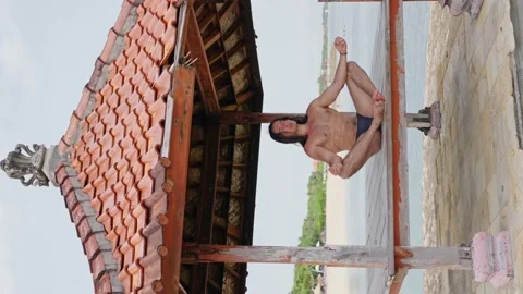 A Man With a Naked torso, Yogi doing meditation on the Beach vertical view Stock Footage 238460129
