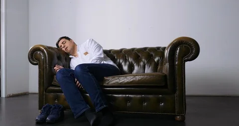 Man Napping on Small Love Seat Waking Up Stock Footage 120432087