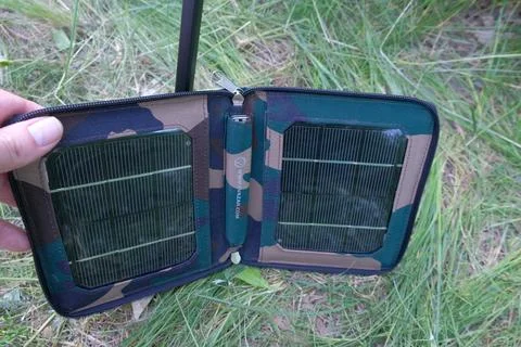 Man in nature testing solar panel for hike visible object human hands grass Stock Photos