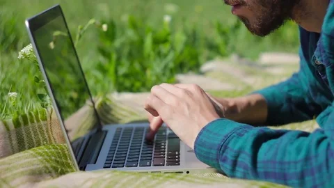 Man in nature typing text on laptop keyboard close-up Stock Footage 76488038
