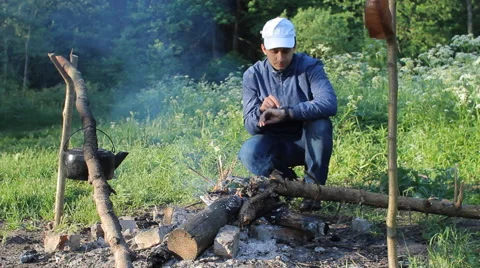Man near fire in forest touch smartwatch Stock Footage 63948363